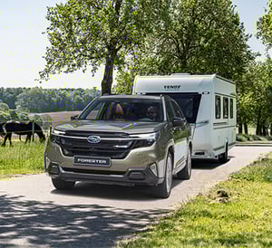 Subaru Forester mit Anhänger auf Feldweg bei Sonneschein
