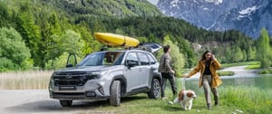 Subaru Forester mit gelben Kajak und jungem Paar mit Hund